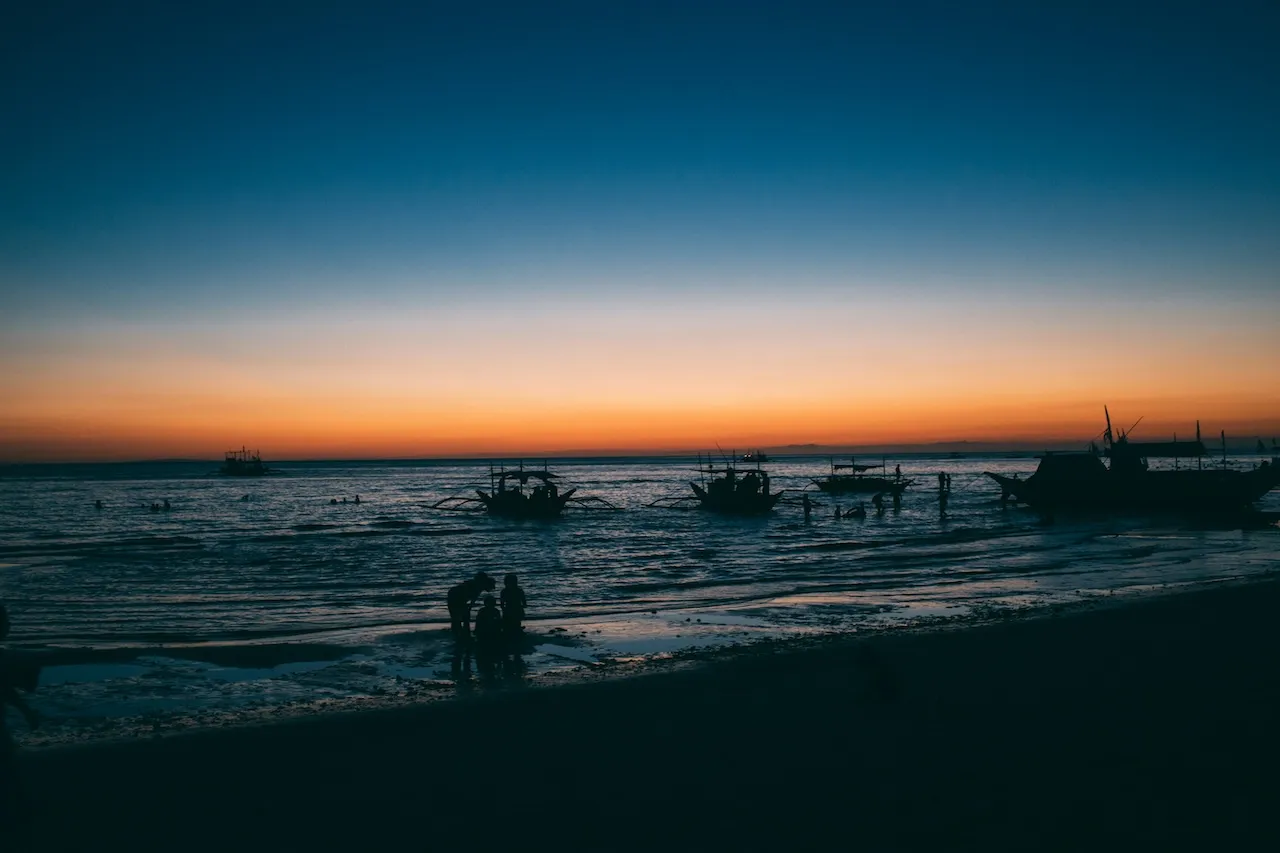 Fishermen by the shore before sunrise